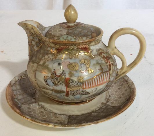 Signed Asian Satsuma Cream Pitcher W Saucer: miniature twapot, cream pitcher, tea service accessories, Comes with saucer plate. measures approximately 4 inches tall and Plate is approximately 5.5 inches in diameter. Set has raised gold toned dec
