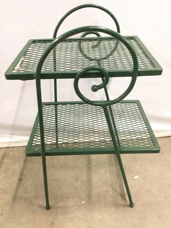 Green Toned Outdoor Planter Stand: Planter stand has 2 levels. Piece has c curve detail on sides. Stand is metal and green toned. Measures approx 23 inches tall 15 inches wide 12 inches deep. Top level appears to need repair. plant sta