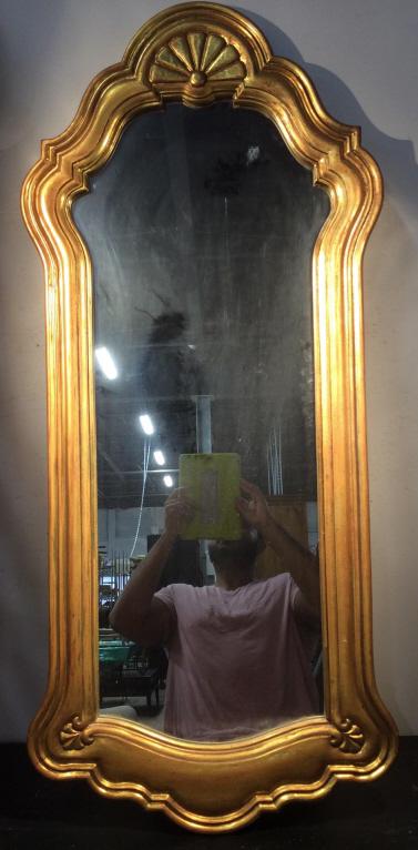 Pair Gold Toned Framed Mirrors: Possibly antique, possibly gold leafed and hand carved. Lot includes 2 mirrors. Each have Uniquely shaped gold toned frames. Frames are Possibly gold Leafed. Each measures approx 47 inches tall 20 inc