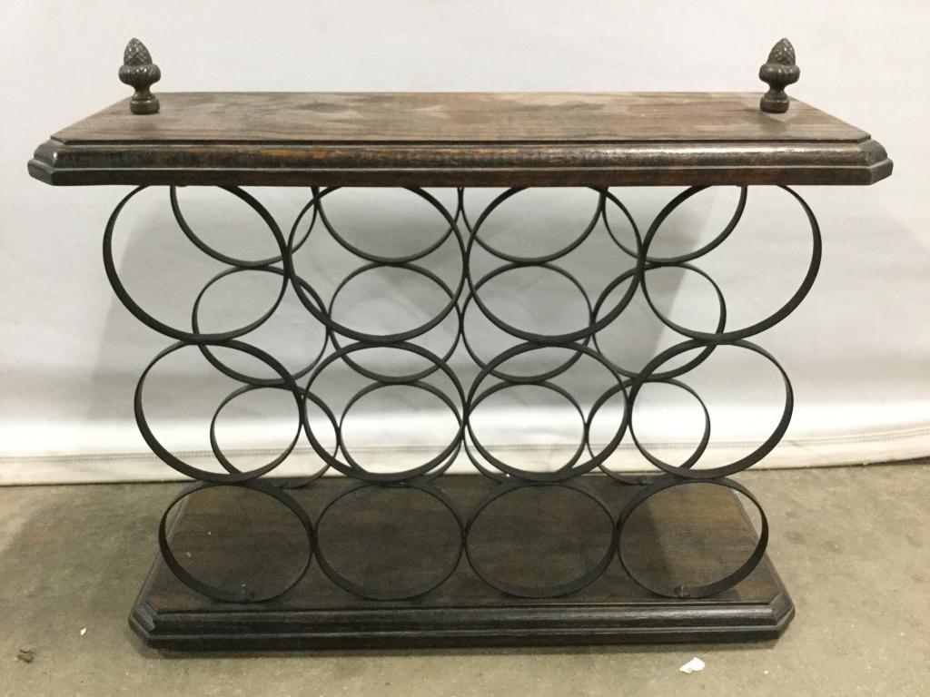 Vintage Wine Rack: Rack includes 12 bottle holding spaces. Top and bottom of piece is wooden. Piece has 2 finials. Measures approx 18 inches long 15 inches tall 7 inches deep. Piece has evident wear and some scratches.