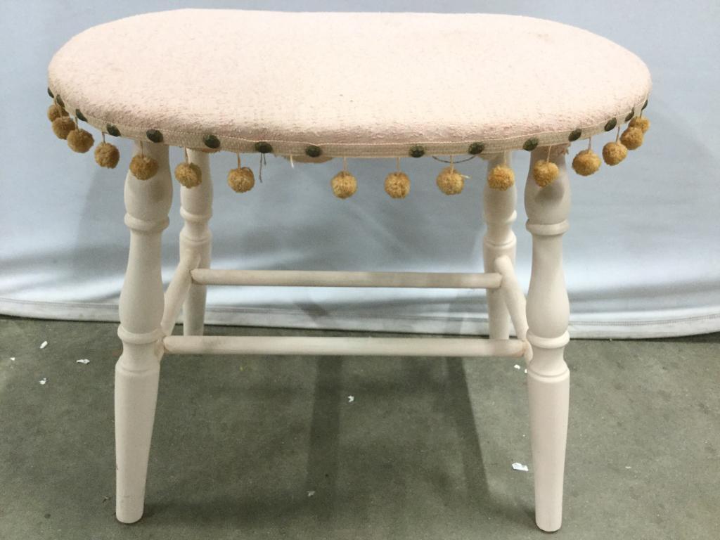 Pink Toned Vintage Bench: Bench is pink toned. Pieces has 4 wooden legs. Seat has small spherical structures hanging from seat. Piece measures approx 23 inches long 18 inches tall 14 inches deep. Some dangling pieces are missi