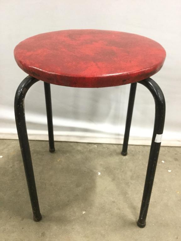 Vintage Stool W Red Toned Seat: Stool seat is red toned. Contains 4 black toned metal legs. Piece measures approx 18 inches tall 12 inches wide and deep. Contains evident wear and small tears to seat upholstery. stool, seat, foot re