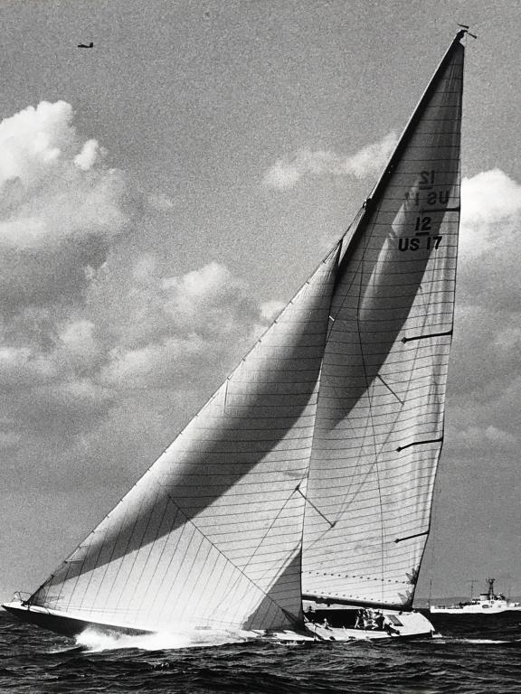 Framed Poster Print Of Boat in America’s Cup: Poster print depicts Weatherly-defender of the America’s Cup 1962. Print is matted and set behind glass in wood frame. Measures approx 25.25 inches in height by 21.8 inches in width with frame. Some