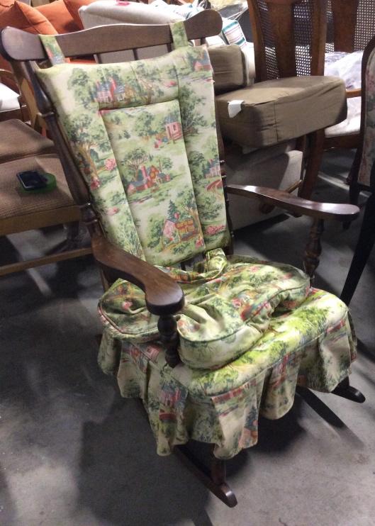 Vintage Carved Wooden Rocker W Cushions: Rocking chair is wooden and brown toned. Piece has Upholstered Seat area with matching loose seat & backrest cushion. Piece measures approx 41 inches tall 26 inches wide, 30 inches deep. Piece & Cushi