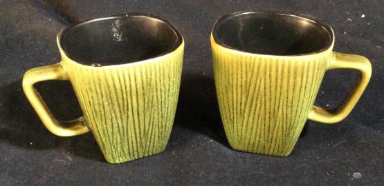 Jade Green Ceramic Pair Of Coffee Mugs: Pair of green ceramic coffee mugs with black inside. Darker green stripes are painted on the outside. Measures 4 inches tall with square bottom. Jade green mugs, green mugs, green coffee mugs, coffee