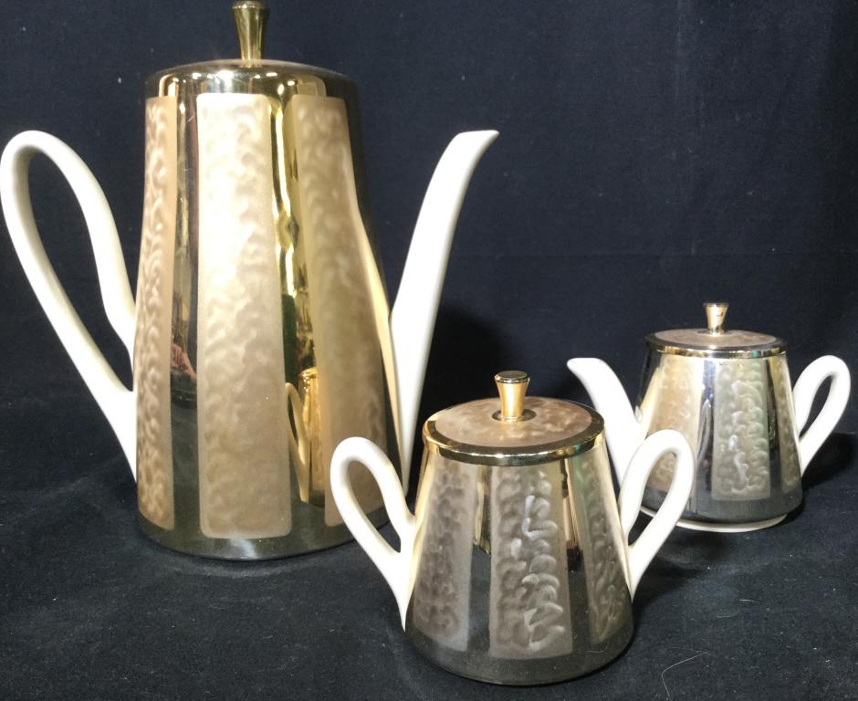 Lot 3 Coffee Pot Creamer & Sugar W Silver Plate: Underside of each is marked TARNISH RESISTANT SILVERPLATE MADE IN WESTERN GERMANY. Lot includes 1 coffee pot, 1 Creamer, and 1 sugar. Each have gold toned metal armor like covers. Each piece includes 
