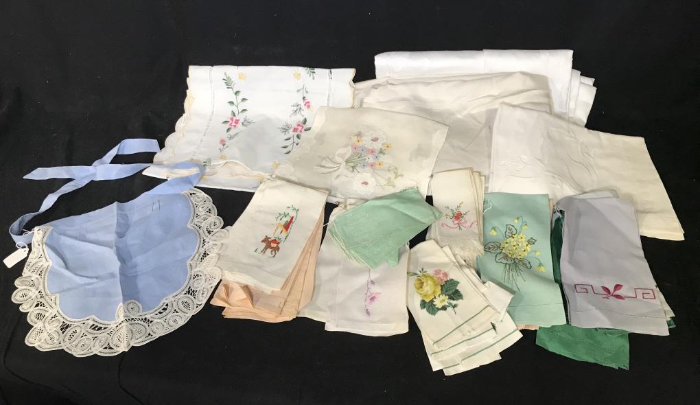 Group Of Vintage Linens: Group Of Vintage Linens consisting of two table cloths, apron, 5 embroidered table runners, various embroidered napkins, and an apron with lace trim, discoloration to some, all different sizes. Vintag