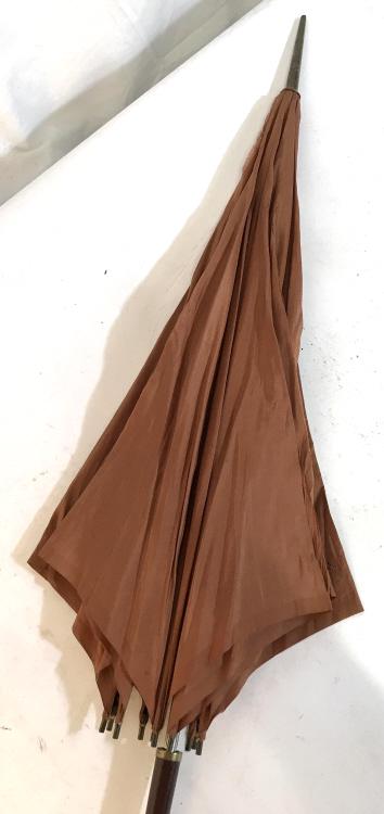 Victorian Ladies Fashion Collectible Parasol: Measures 36 inches in length. Antique wear on fabric. Made from silk, wood, and bone. Handle is likely bone. Decorative tassel. Silk is a brown or burnt orange. Worn gold toned metal hardware. Parasol