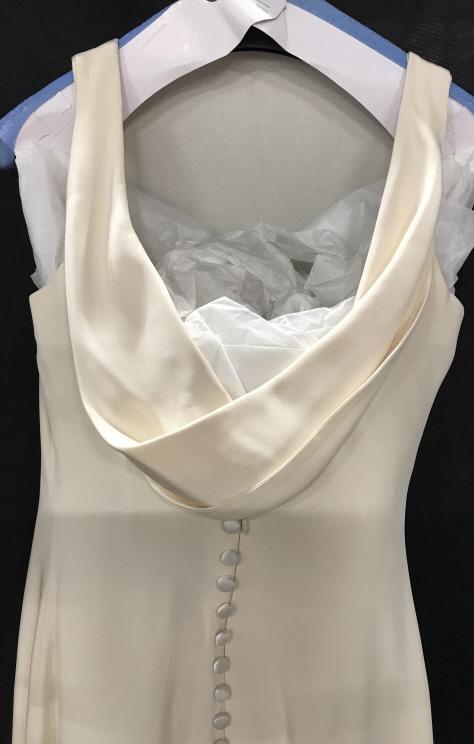 VERA WANG CREAM COLOR SHEATH CREPE DRESS: Luxury Designer Vera Wang Off White Color Dress, Size 8. Tag reads ‘Vera Wang’ additional tags read ‘ Dry Clean Only’ ‘Size 8, Made in USA, Style 727’. Zipper back with accent fabric butto