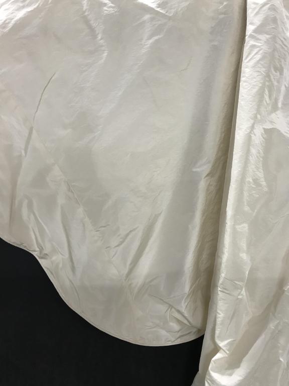 Round Satin Table Cover, Custom Made: Cream Color and fully hemmed with piping. Custom Made. Underside is white cotton fabric. One section of discoloration on satin noted. Up cycle material if desired. Radius, 124 in. Table Covering, Sati