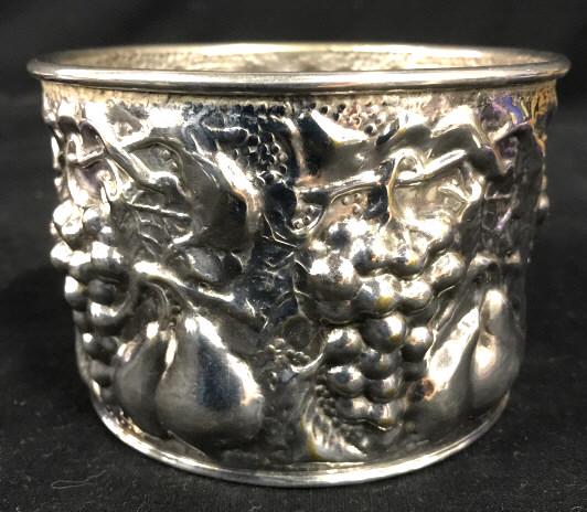 B D Howe’s & Son Wine Bottle Coaster: B D Howe’s & Son Silver Toned Metal Wine Bottle Coaster With Repousse Pear, Grape and Vine Design. Marked on underside with B D Howe’s and Son California Arizona sticker. Some brass toned metal sh