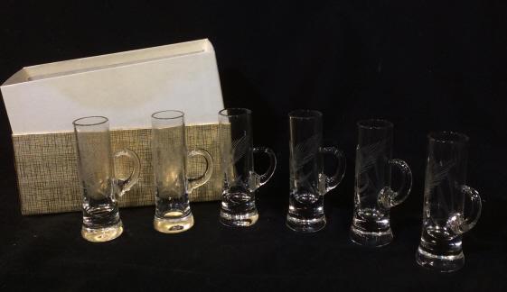 Set 6 Vintage Glass Shooters with Handles: 6 glass shooters approximately 4.5 inches tall. Each shooter has a carved design of a plant. Each shooter has a decorative handle. Needs cleaning. Comes in box. Vintage glass, collectible, collectible
