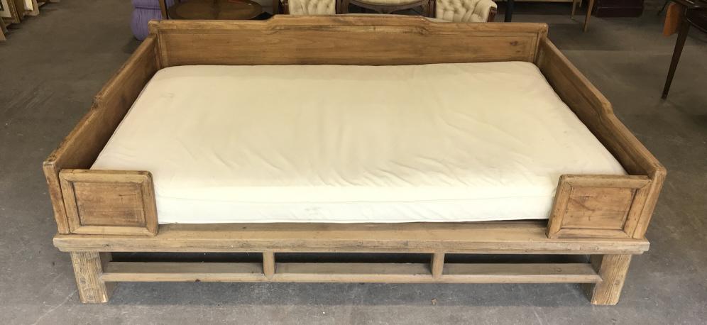 Asian Style Wooden Daybed With Cushion: Asian Style Wooden Daybed With cream toned cushion, constructed of pine toned wood and woven base under cushion, some chips to front legs and minor surface scratches. Measures approx 94 inches wide x 