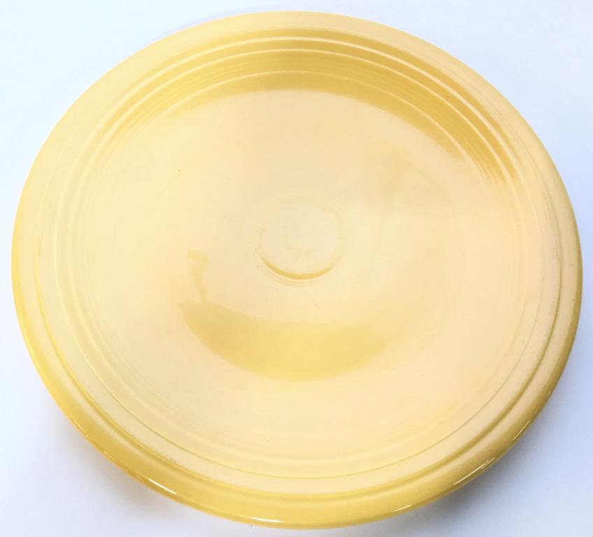 Yellow Toned Porcelain FIESTA Plate, Fiestaware: Underside reads FIESTA USA. Plate is yellow toned. Measures approx 14 inches wide. fiestaware, tableware, serving platter, shelf piece 6.