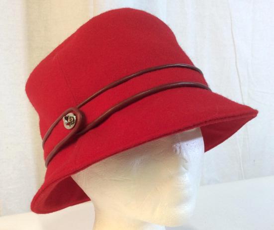 COACH Red Wool Blend Ladies Hat: COACH Red Wool Ladies Hat with wool and leather band and silver toned metal clasp, interior is lined with Coach signature patterned fabric in chocolate and black tones, brown leather tag is sew to int