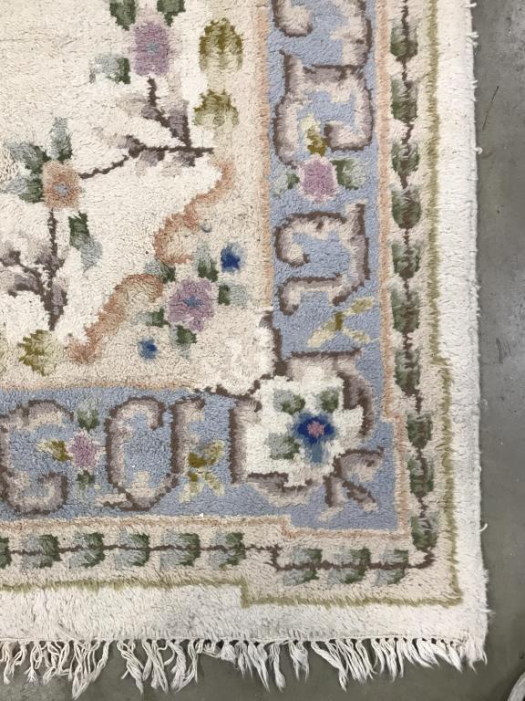 Handmade Floral Detailed Wool Rug: Rug is handmade with multi toned floral detail including tones of light blue, green, cream, and beige. Rug has fringes. Measures approx 112 inches long 64 inches wide. Home accessory and decor, decora