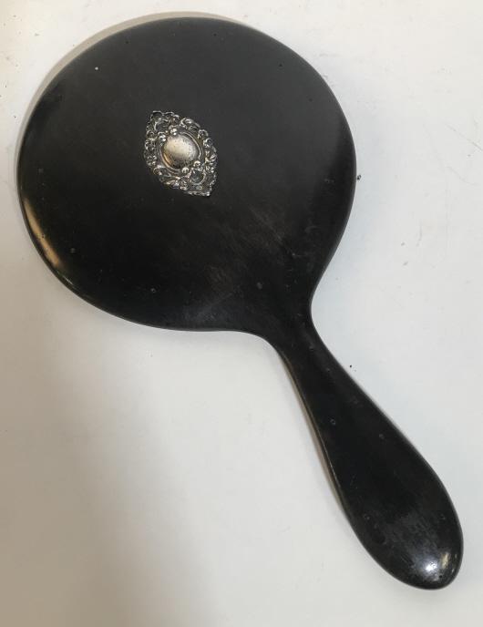 ANTIQUE GENUINE EBONY HANDHELD MIRROR: Handheld mirror believed to be antique. Black colored ebony. Decorative silver-toned accent piece on back. Mirror needs cleaning. Mirror is approximately 4.5 inches in diameter. Vintage, antique, mirr