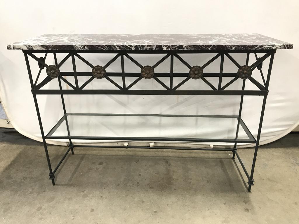 Vintage Iron And Marble Topped Console Table: Vintage Iron And Marble Topped Console Table with lower glass shelf, Top is constructed of maroon, black, grey and white swirled marble stone, top of base has rosette boarder, measures approximately 4