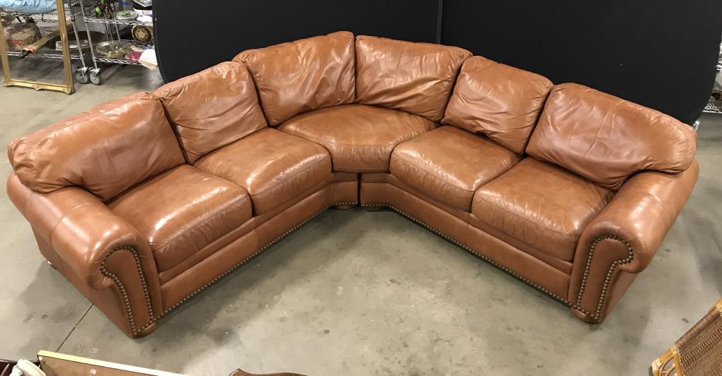 Brown Leather Sectional Leather Tech Sofa: Brown Leather rounded Sectional Leather Tech Sofa with nailhead trim, comes in two pieces, measures approximately 78 inches from right arm to center back, 78 inches from left arm to center back, 139 i