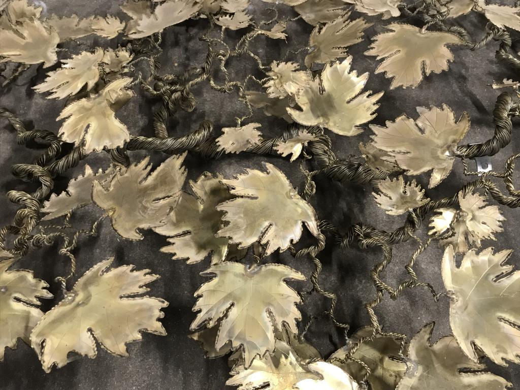 Mid-Century Metal Leaf Wall Hanging Sculpture: Mid-century metal leaf wall hanging sculpture art, brass in tone. Sculpture is made up of leaves on wire branches. Measures approx 51 inches in width by 30 inches in height by 5 inches in depth. Mid-c