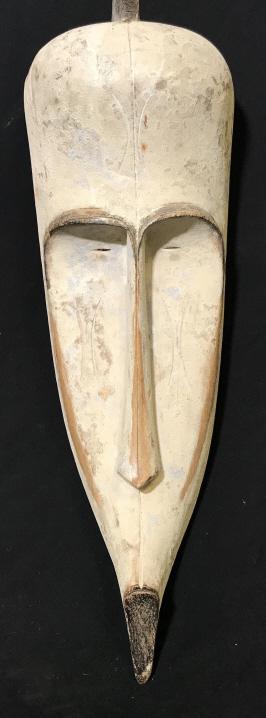 African Art Fang Tribe Carved Wood Ngil Mask: African Fang Tribe Wooden Ngil mask from Gabon, Central Africa. Mask features white tone painted wood. Elongated face mask has incised eyes. Measures approx 23.5 inches in length by 8 inches in width 