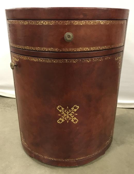 Circular Leather Clad Table W Gold Toned Design: Circular Leather Clad Side Table In Red Brown Toned Leather With Gold Toned Painted Boarder Design, one top drawer over lower cabinet, some surface scratches to leather and wear to gold paint in areas