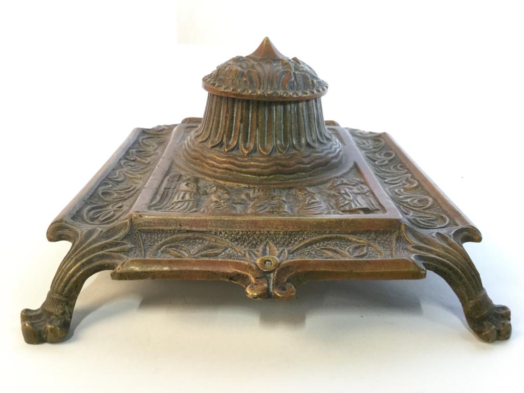 Antique Gothic Style Gold Toned Footed Inkwell: Inkwell is gold toned and footed appears to be Bronze. Contains intricate ornate detail with floral, leaf, & Figural Detail. Measures approx 7.5 inches long, 6 inches wide, 3 inches tall. writers acce