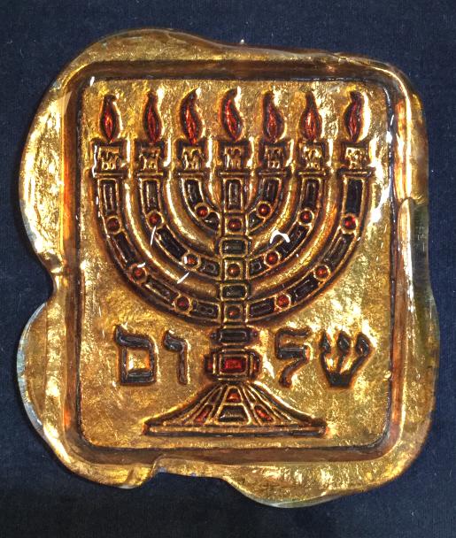 Lot 2 MURANO Glass Judaica Panels: Lot includes 2 art glass panels. Tag on backside reads MURANO MADE IN ITALY. 1 has depiction of Menorah, the other has Hebrew Characters. Each have irregular shapes. Both are attached to black toned p