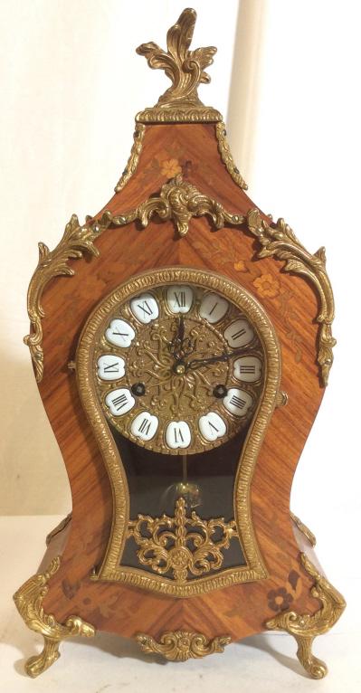 FRANZ HERMLE & SONS Ornate German Clock: Piece is Marked FHS GERMANY on Interior. Piece appears to be wooden and brass. Clock is ornately Detail with c, s curve and footed detail. Contains an ornate clockface, with Roman numerals. Piece meas