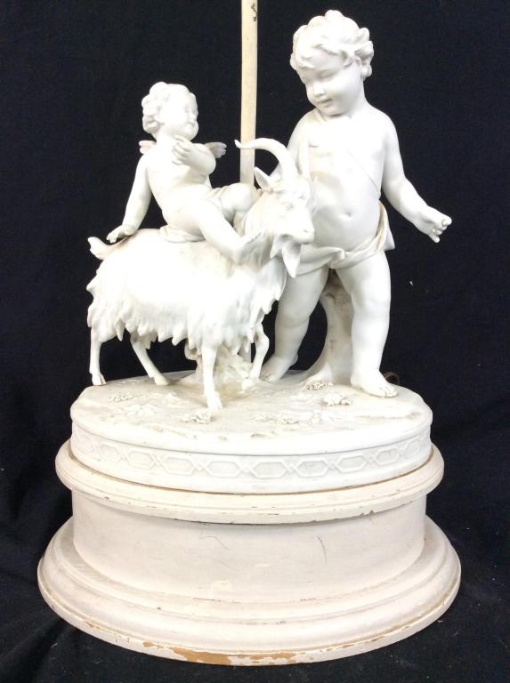 MARION Signed Cherub Lamp: Porcelain with a wooden base, Lamp appears to be signed MARION and has blue Toned Trademark. Pieces depict 2 cherubs & a ram. Measures approx 27 inches tall 11 inches wide 9 inches deep. Contains some