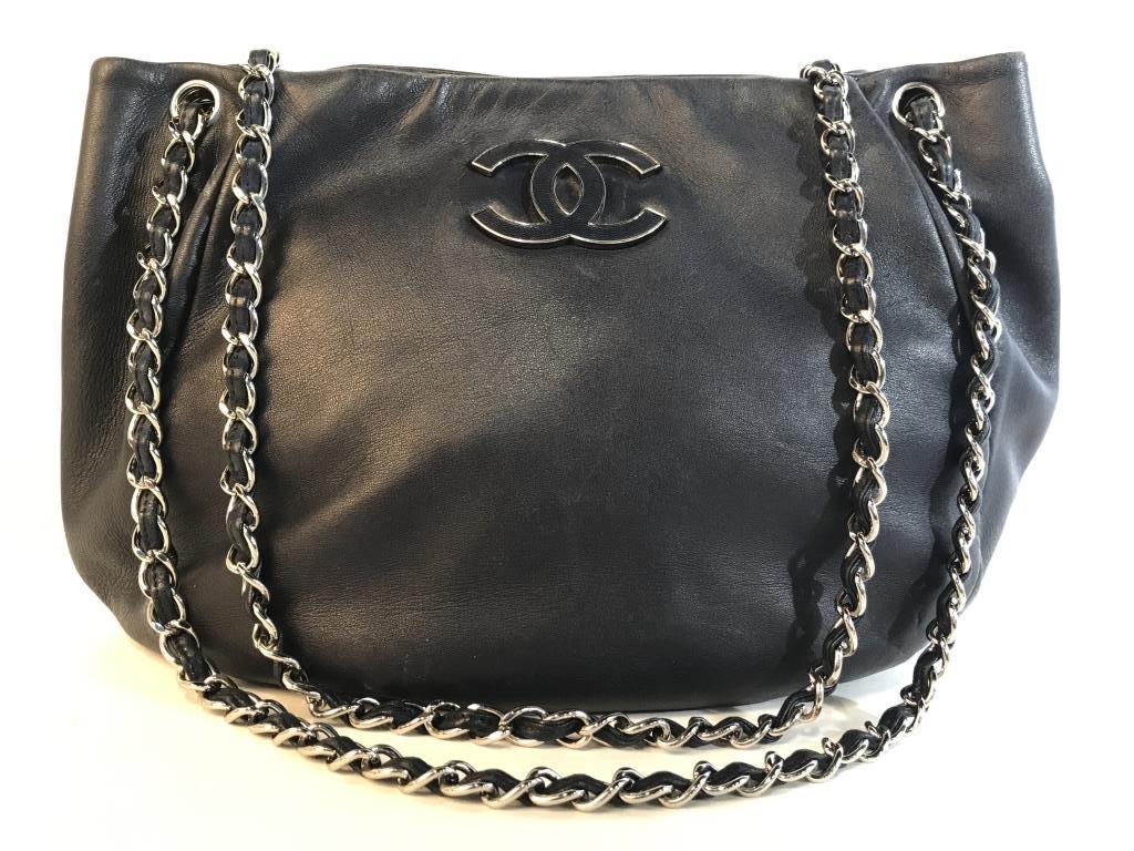 Authentic CHANEL Luxury Designer Leather Handbag: Authentic CHANEL luxury Designer soft leather satchel handbag. Deep navy blue tone leather with silver tone metal details in chain strap and Chanel logo On exterior. Snap button closure. Leather label