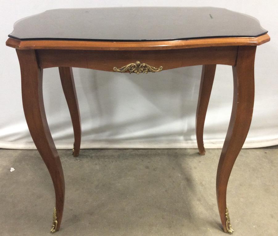 Vintage Wooden Table W Glass Top: Table is wooden. Contains ornate gold toned accents on feet and near tabletop. Piece measures approx 23 inches tall 21 inches wide 17 niches deep. end table side table, occasional table, home furnishi