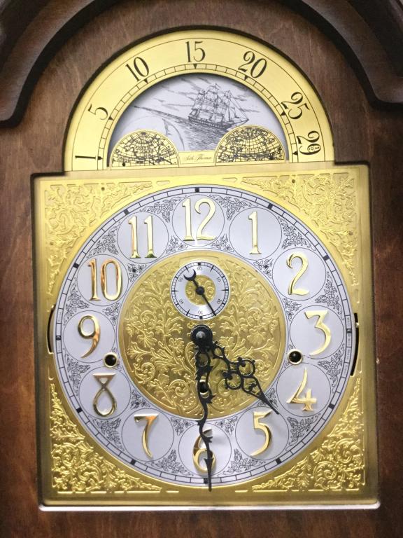 Vintage SETH THOMAS Grandfather Clock: Clock face reads SETH THOMAS. Structure of piece has intricately carved wooden detail. Clockface is Gold toned with White and Black Toned with black toned hands and gold toned numerical digits. Gold t