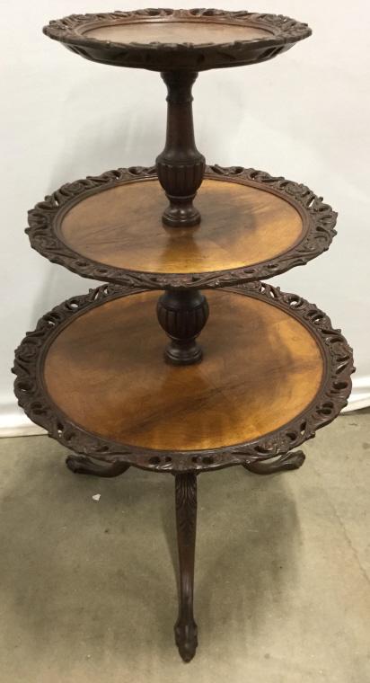 Antique Carved Wooden Dumb Waiter: Piece has intricately carved wooden detail around edges and at feet. Piece has 3 levels each of which are larger near bottom. Piece has 3 feet resembling claw and ball style. Dumb waiter, carved woode