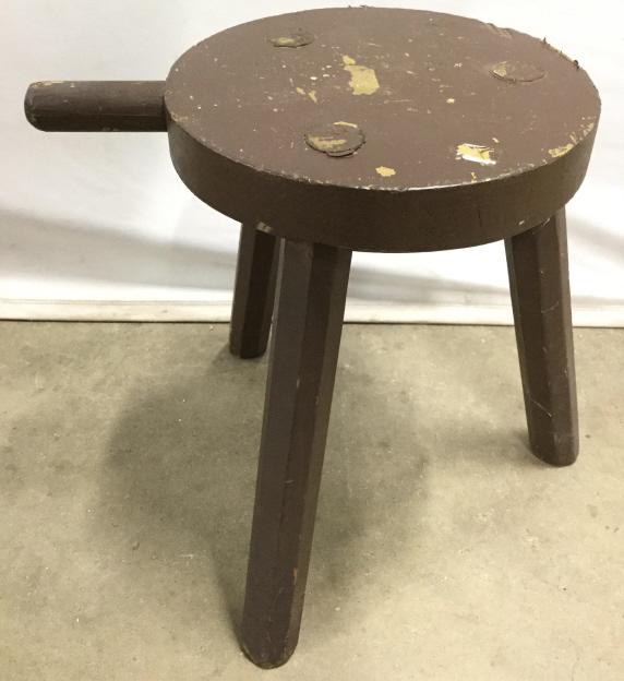 Antique Wooden Milking Stool: Milking stool is chocolate toned and wooden. Piece has Bucket holder on front. Piece has 3 legs and rounded seat surface. Piece measures approx 16 inches tall and wide with bucket holder. Piece has ev