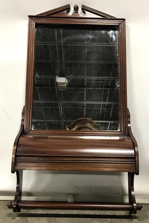 Antique Wall Shaving Mirror W Compartment & Rack: Antique gentleman’s wall shaving mirror with lift-cover compartment and towel rack. Mirror’s frame is possibly mahogany wood with federal style top pediment. Measures approx 32.8 inches in height 