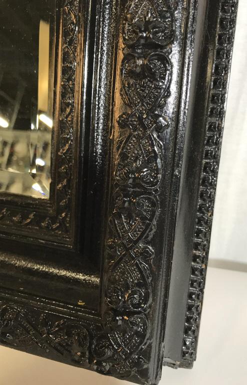 Hand Carved Antique Early American Mirror: C. 1880 approx 20 x 26 x 2 1/4 in. Wired to hang vertically. Wood has been painted over in glossy black. Mirror has a bevel and measures 11.5 x 17 3/8 in. No noticeable nicks in wood. Seams in tact an
