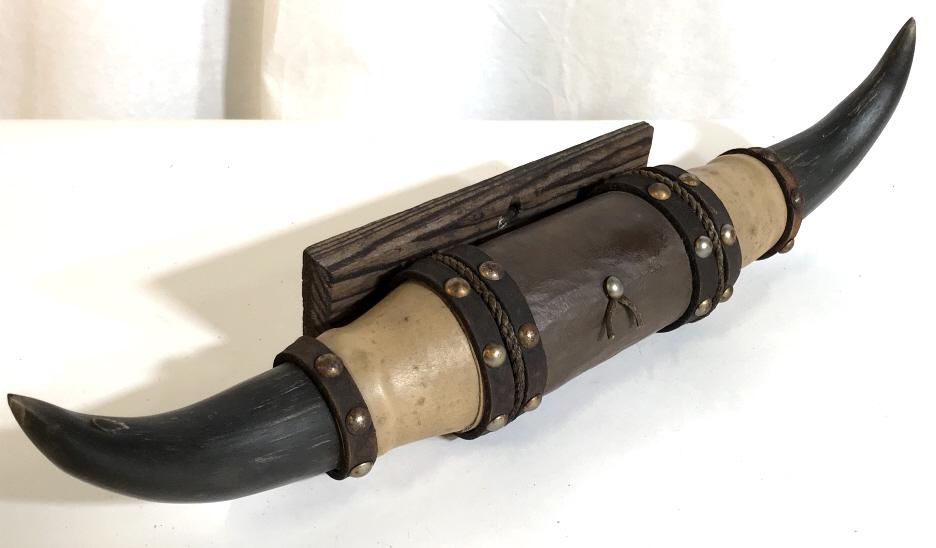 Country Animal Horns Wall Decor: Possibly a Steer horns. Horns wrapped in detailed leather straps and added brass accent stud tacks. Rustic wood plaque to hang on wall. Plaque has top hole for nail. Measures 8 x 3 x .5 in. Horne meas