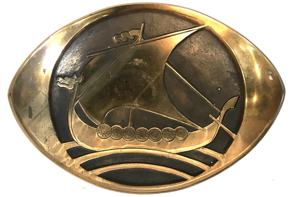 Mid-Century Danish Bronze Viking Decorative Plate: Metal plate is possibly polished bronze or coated bronze, with Viking boat motif set in Relief. Marked on underside for ‘Denmark.’ Measures approx 2.75 inches in height by 10.5 inches in width by 