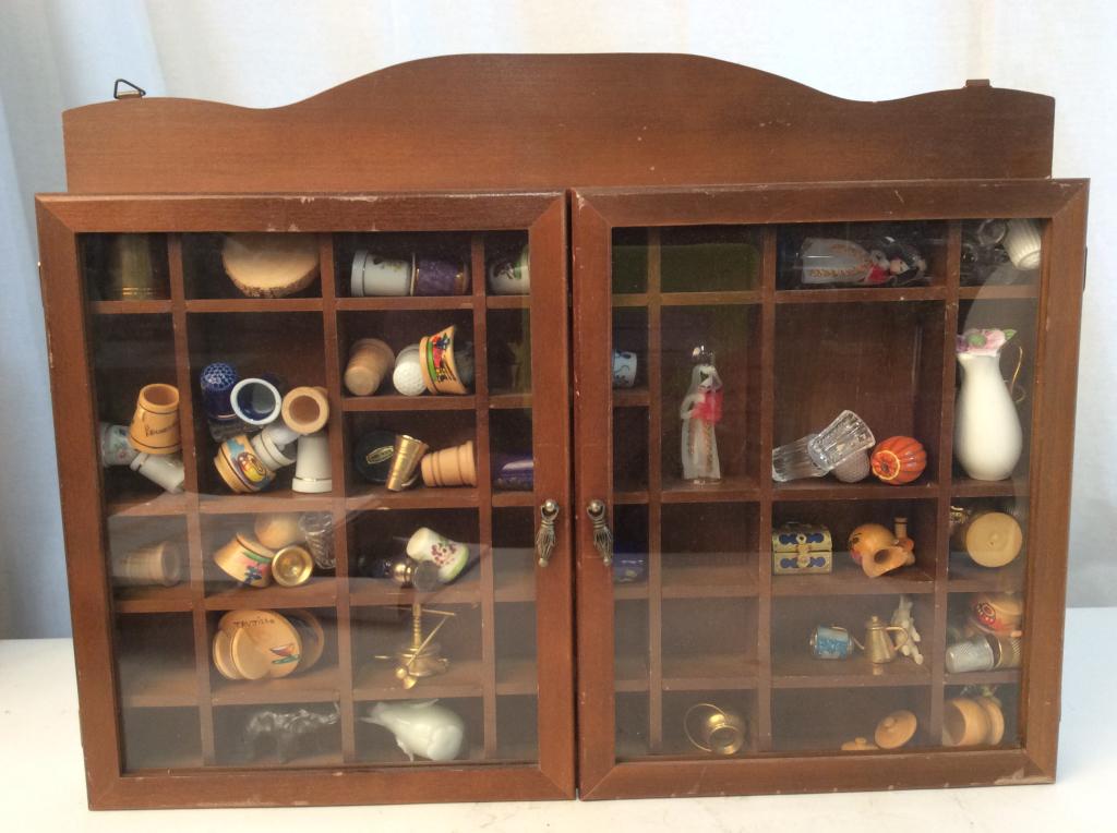 Vintage Glass/Wood Display w Group Collectibles: Vintage wall mount wood/glass display. 2 doors opening to multiple shelf and compartments. group Lot also includes porcelain thimble collection and miniatures, brass smalls, Mini elephants, Painted Wo