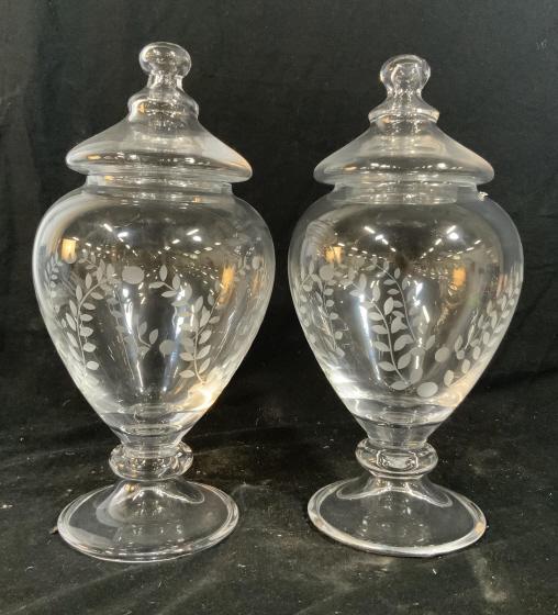 Pair Etched Footed Crystal Apothecary Vessels: Lidded glass crystal pedestal vessels, apothecary jars, candy vessels, decorative tableware, decorative accessories, lidded urns, each measures ht 14 inches diameter app 8 inches