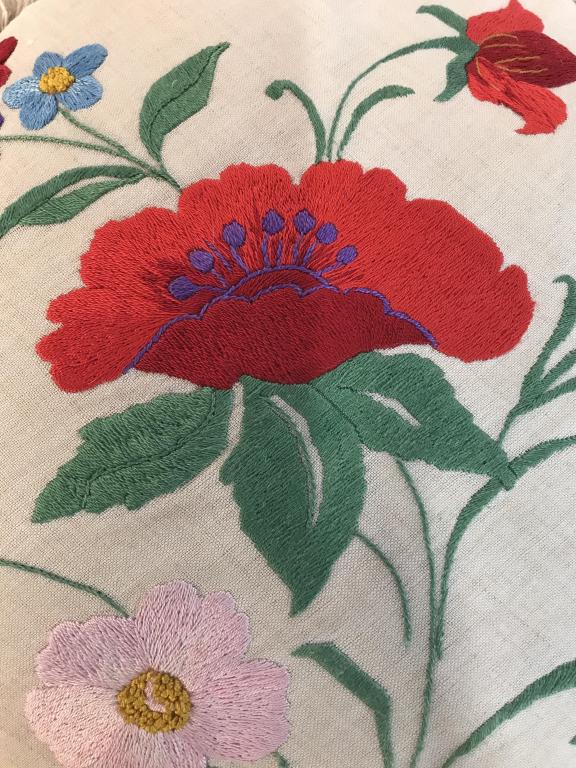 Vintage silk floral embroidered throw pillow: Vintage circle shaped couch pillows with embroidered silk flowers on front. Fringes around perimeter of Pillow. Discoloration. Measures approximately 18 inches in diameter. Red reflective material on 