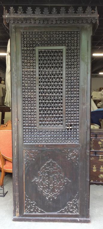Extra Tall Antique Moorish Fretwork Cabinet: Single door wooden cabinet with intricate fretwork panels. Interior has multiple shelves. Measures approx. Cabinet has moderate surface wear due to age, including chips/cracking to wood. Cabinet will
