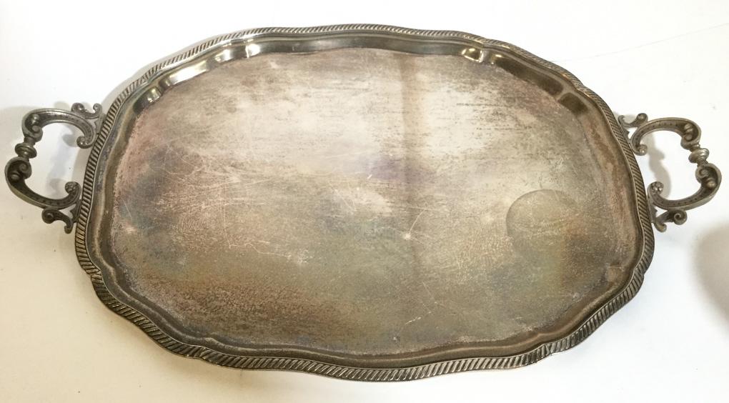 Silver Toned Metal Serving Tray: Serving tray is silver toned and metal. Piece has handle on each side. Measures approx 20 inches long 13 inches deep. tray, serving platter, silver toned metal, platter, tableware, tabletop accessory 