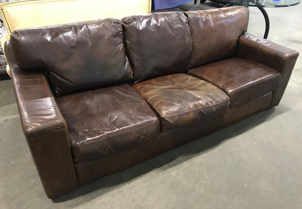 Vintage Chocolate Toned Leather Three Seat Sofa: Vintage Chocolate Toned Leather Three Seat Sofa, cracking, wear, scratches, discoloration to areas, base under cushions, measures approximately 90 inches long x 38.5 inches deep x 35 inches tall to to