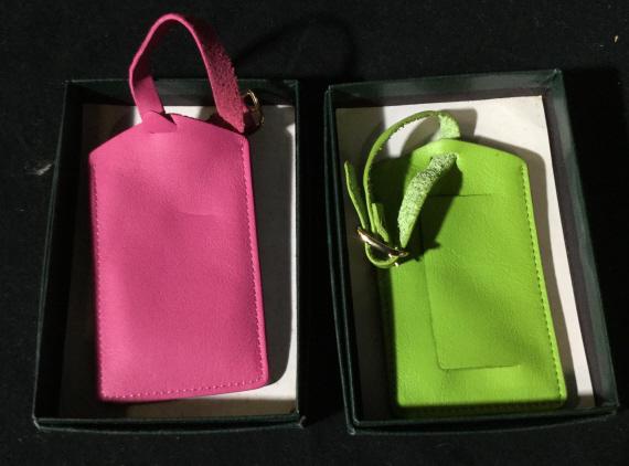 Pair Colorful luggage tags: Pair of luggage tags. Possibly leather. Buckle closure. One tag has empty identification card. Pink and green. Luggage tag, luggage, travel, travel tag, tag suitcase, suitcase accessory, airplane, fli