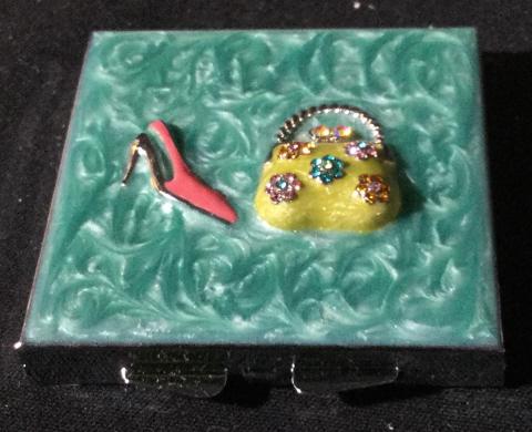 Vintage crafted square compact mirror: Vintage compact mirror. Measures approximately 2.5 by 2.5 inches. Two mirrors inside. Comes with original box and protective film still in tact on back. Front features a purse and high heel. Clasp clo
