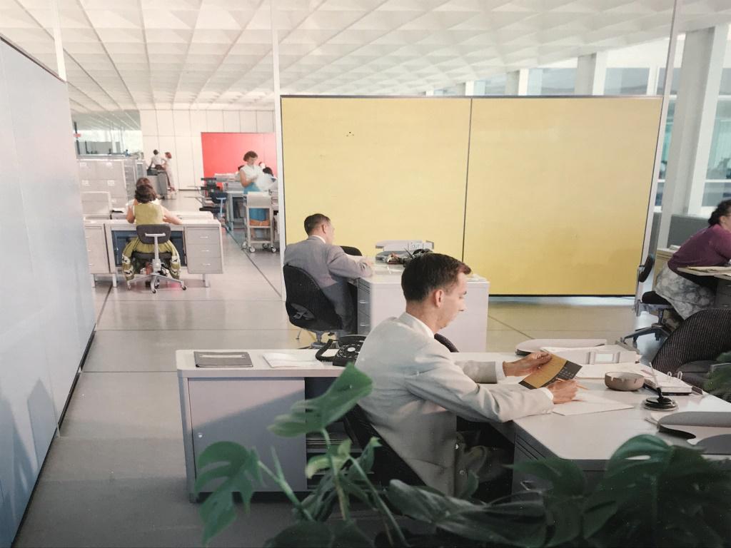 Framed Lithograph, Vintage Office Interior: Framed Lithograph of photograph of vintage working interior. Possibly an offset lithograph. Print is set behind plexiglass in white tone wood frame. Measures approx 16.5 inches in height by 24.25 inch