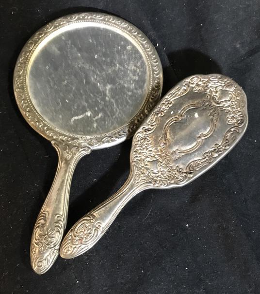 Mid Century Art Nouveau Hand Mirror & Hairbrush: Lot 2. Floral and scroll patterns in relief on silver toned metal, possibly silver plated. Mirror has added tack trim design and has weight to it. Measures 9 in. long, 5 1/4 in wide. Brush has similar