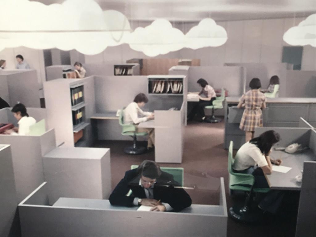 Framed Lithograph, Vintage Office Interior: Framed stylized Lithograph of vintage working interior. Possibly an offset lithograph. Print is set behind plexiglass in white tone wood frame. Measures approx 16.5 inches in height by 24.25 inches in